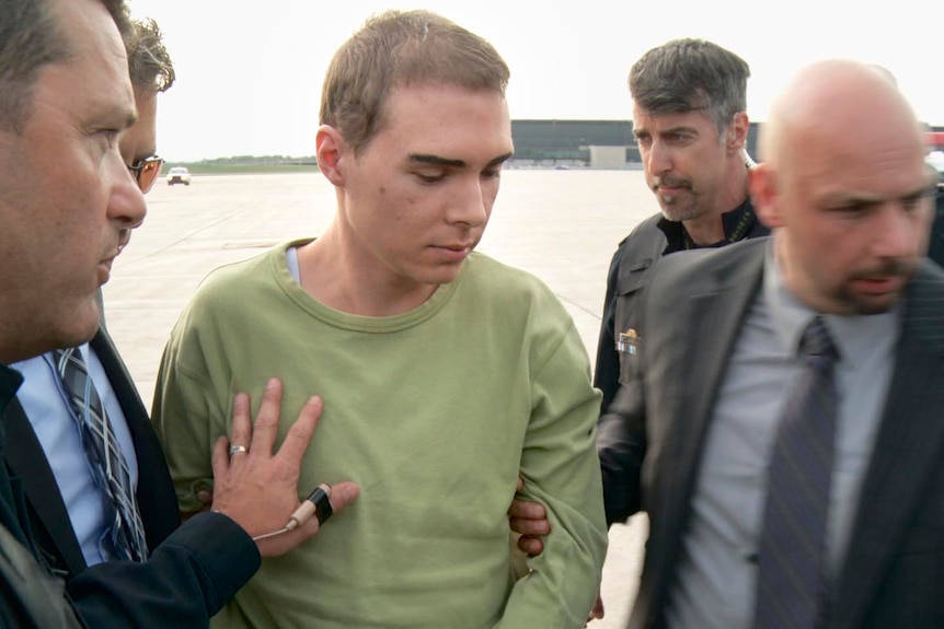 Accused killer, Luka Rocco Magnotta. is escorted by police upon arrival in Montreal.