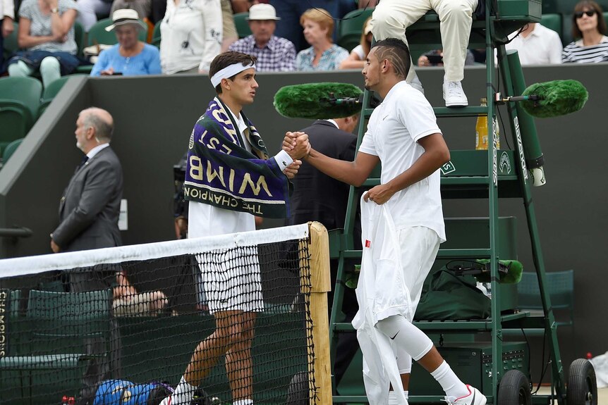 Nick Kyrgios shakes hands with France's Pierre-Hugues Herbert after sustaining an injury
