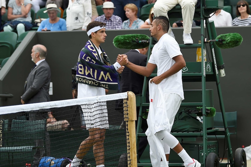 Nick Kyrgios shakes hands with France's Pierre-Hugues Herbert after sustaining an injury