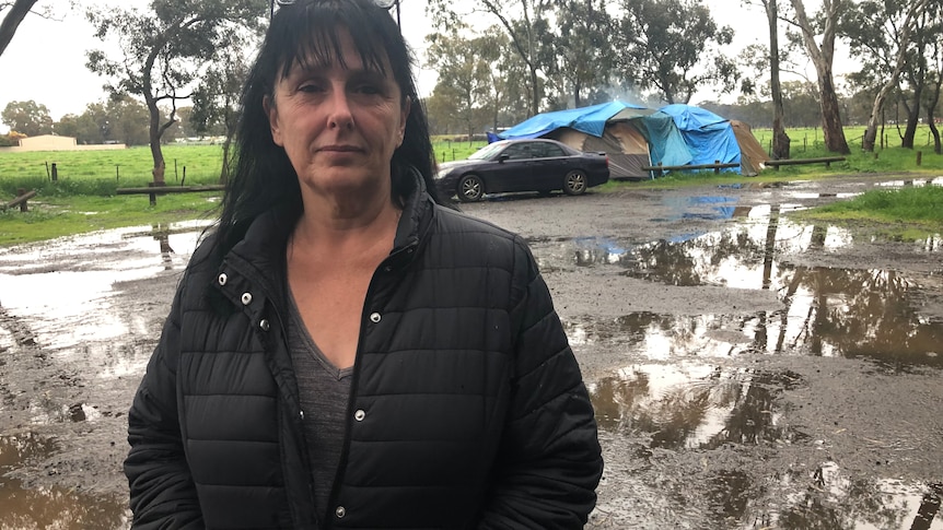 woman with car and tent in background