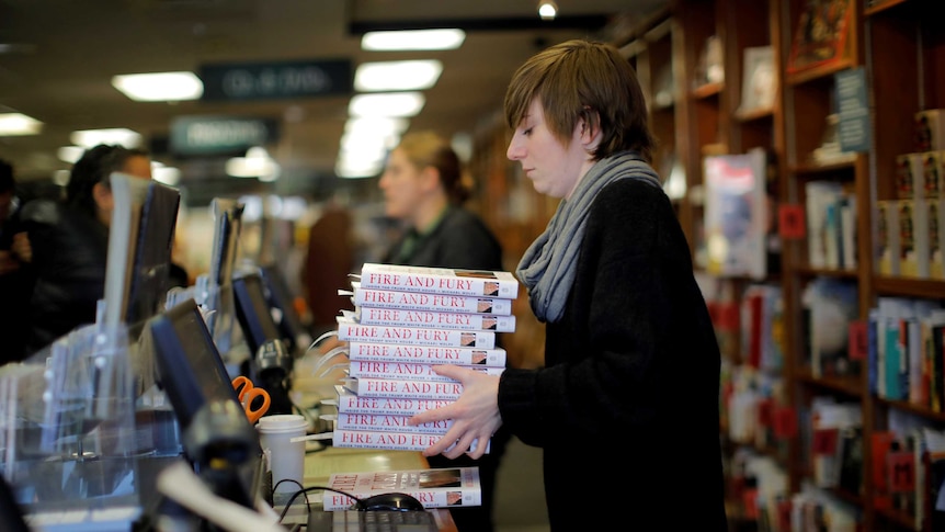 An employee holds copies of the book "Fire and Fury: Inside the Trump White House".