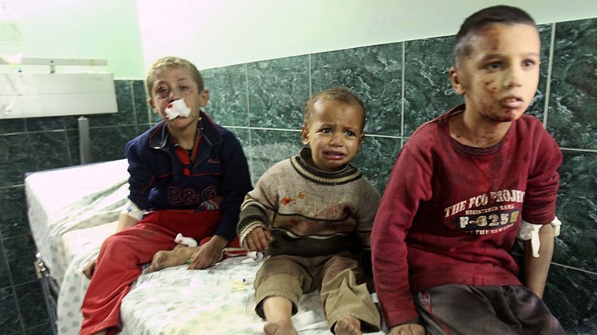 Palestinian boys wounded by an Israeli tank shell wait for treatment at Shifa hospital