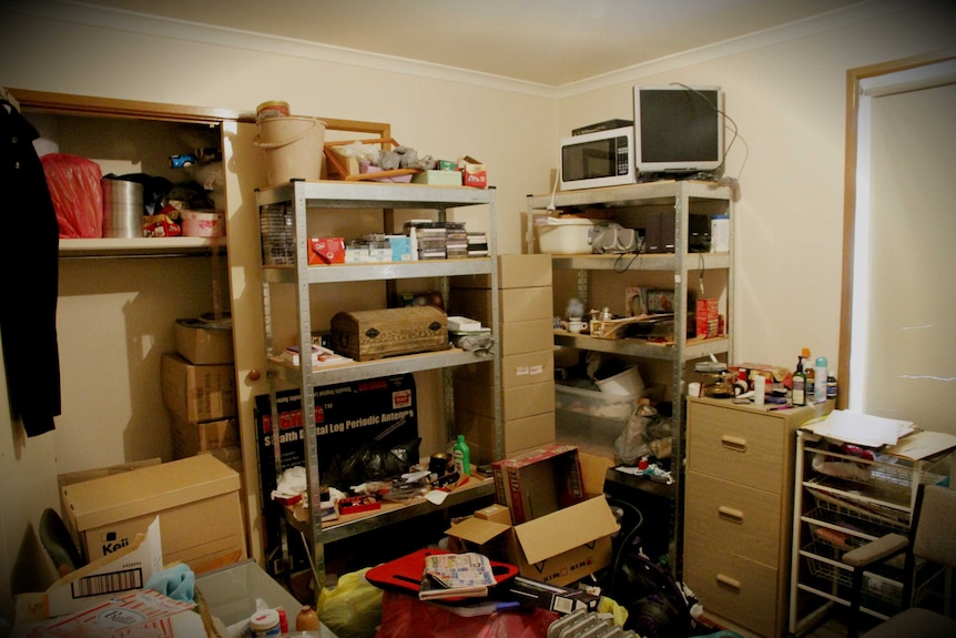 A cluttered spare room with boxes of things that still need to be sorted