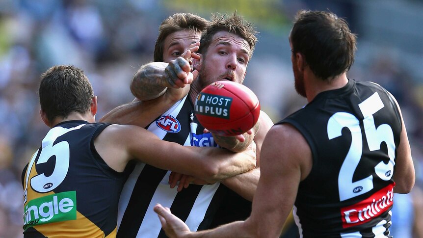 Magpies' Dane Swan looks to hold off the Tigers' Chris Knights at the MCG.