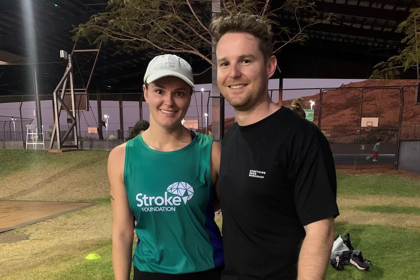 A young man and woman smiling. The woman wears a green shirt that reads 'Stroke Foundation'.