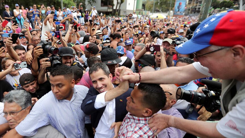 Venezuelan opposition leader Juan Guaido is mobbed by a huge crowd of supporters.