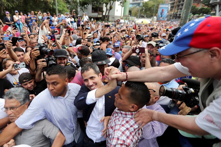 Venezuelan opposition leader Juan Guaido is mobbed by a huge crowd of supporters.