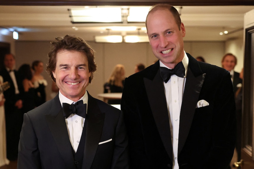 Tom Cruise and Prince William pose for photos in tuxedos. 