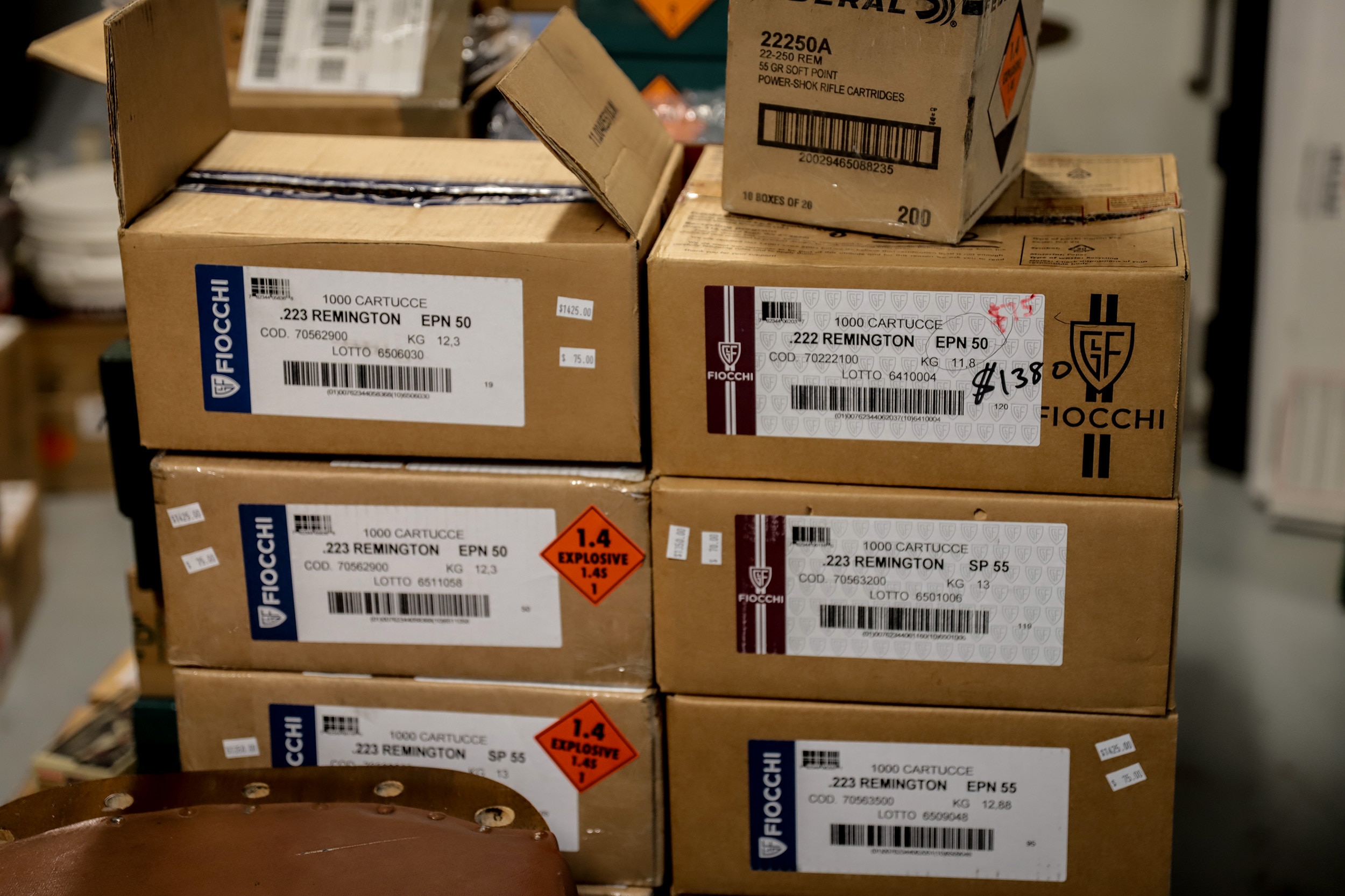 Brown cardboard boxes stacked on top of each other. They have a white label and an orange explosive label.