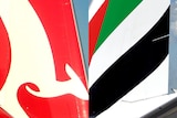 LtoR Tails of a Qantas and Emirates plane.