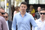 Liam Knight (C) arrives at the Downing Centre court