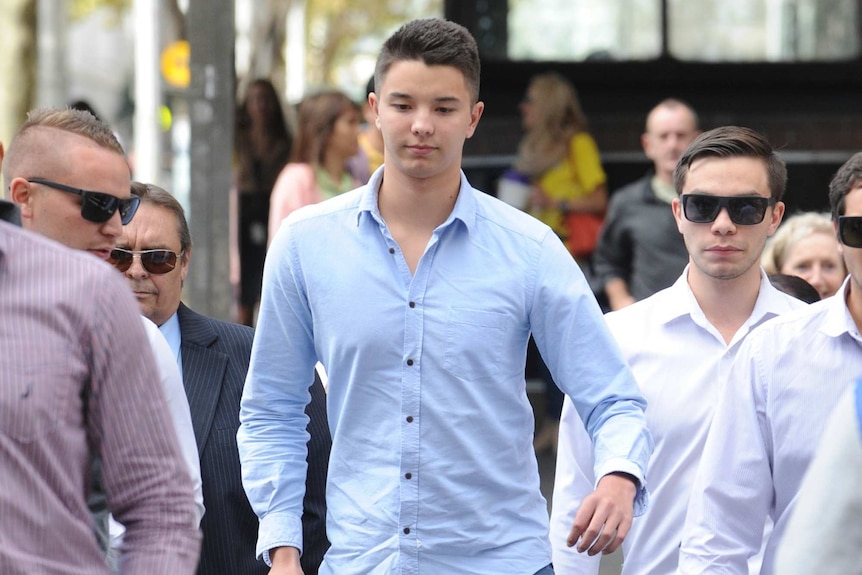 Liam Knight (C) arrives at the Downing Centre court