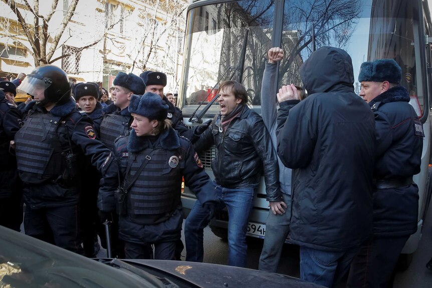A protesters blocks a police van carrying opposition figure Alexei Navalny.