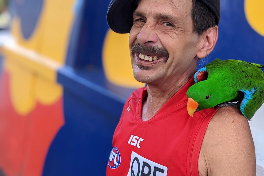 Mr Gawronski smiling with a parrot on his shoulder.