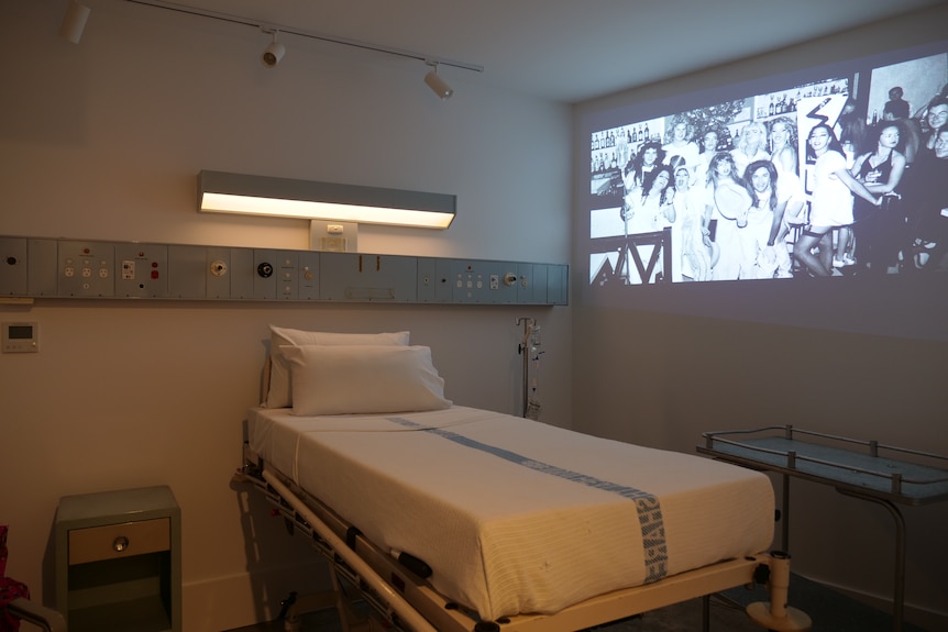 a hospital bed in a dark room with a projection on the wall
