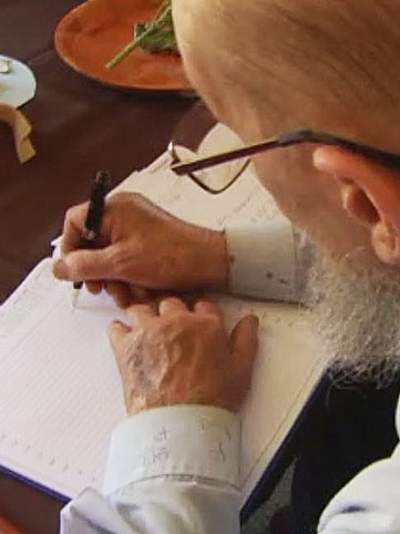 Peter Jones copies a rainfall measurement from his cuff to his book.