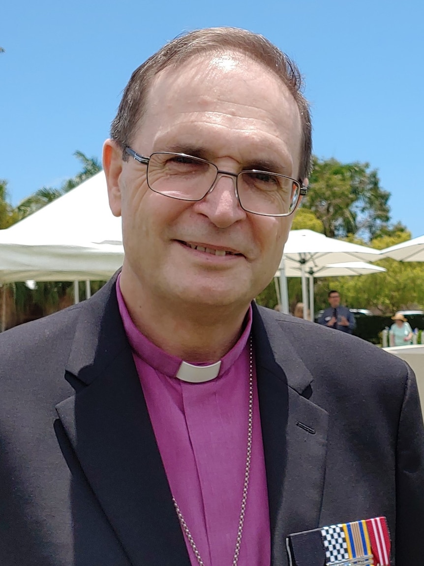 Close up of Bishop wearing glasses standing outside