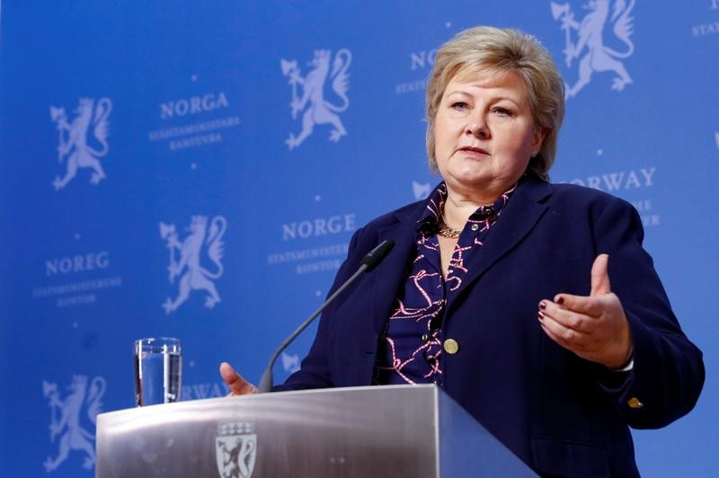 Prime Minister Erna Solberg speaking on stage in a microphone.