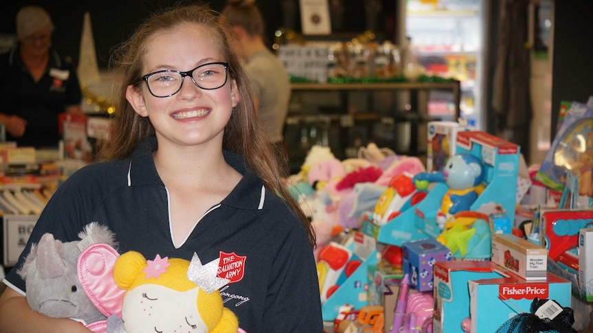 A young girl clutches colourful toys