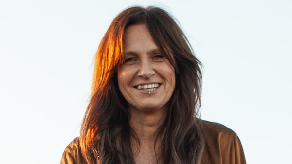 Close-up of musician Kasey Chambers, smiling and framed by her tousled brown hair