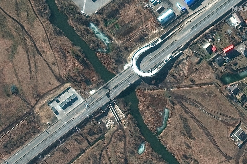 A bridge seen from above with damage from shelling.