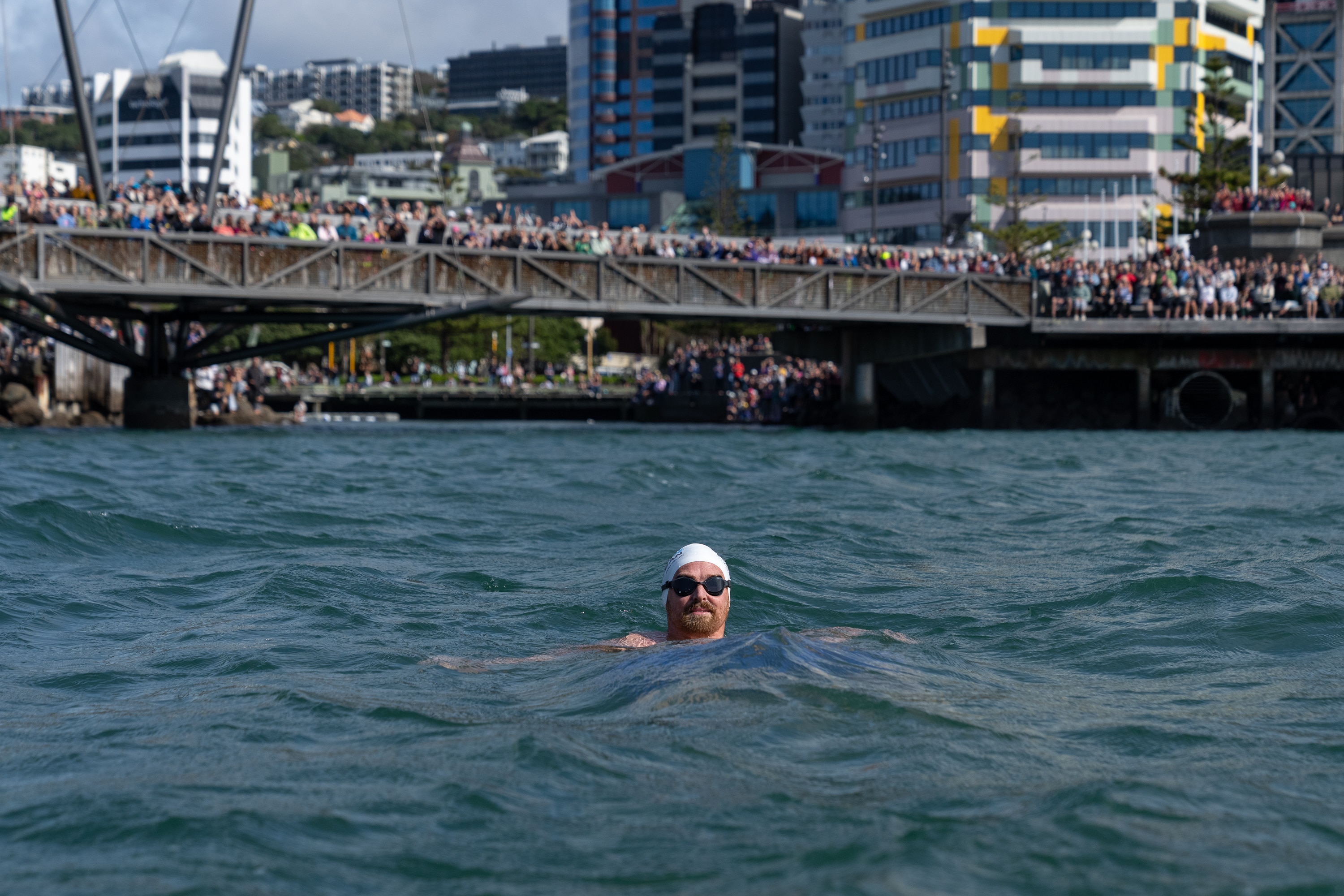 Jono Ridler with people on a bridge behind him