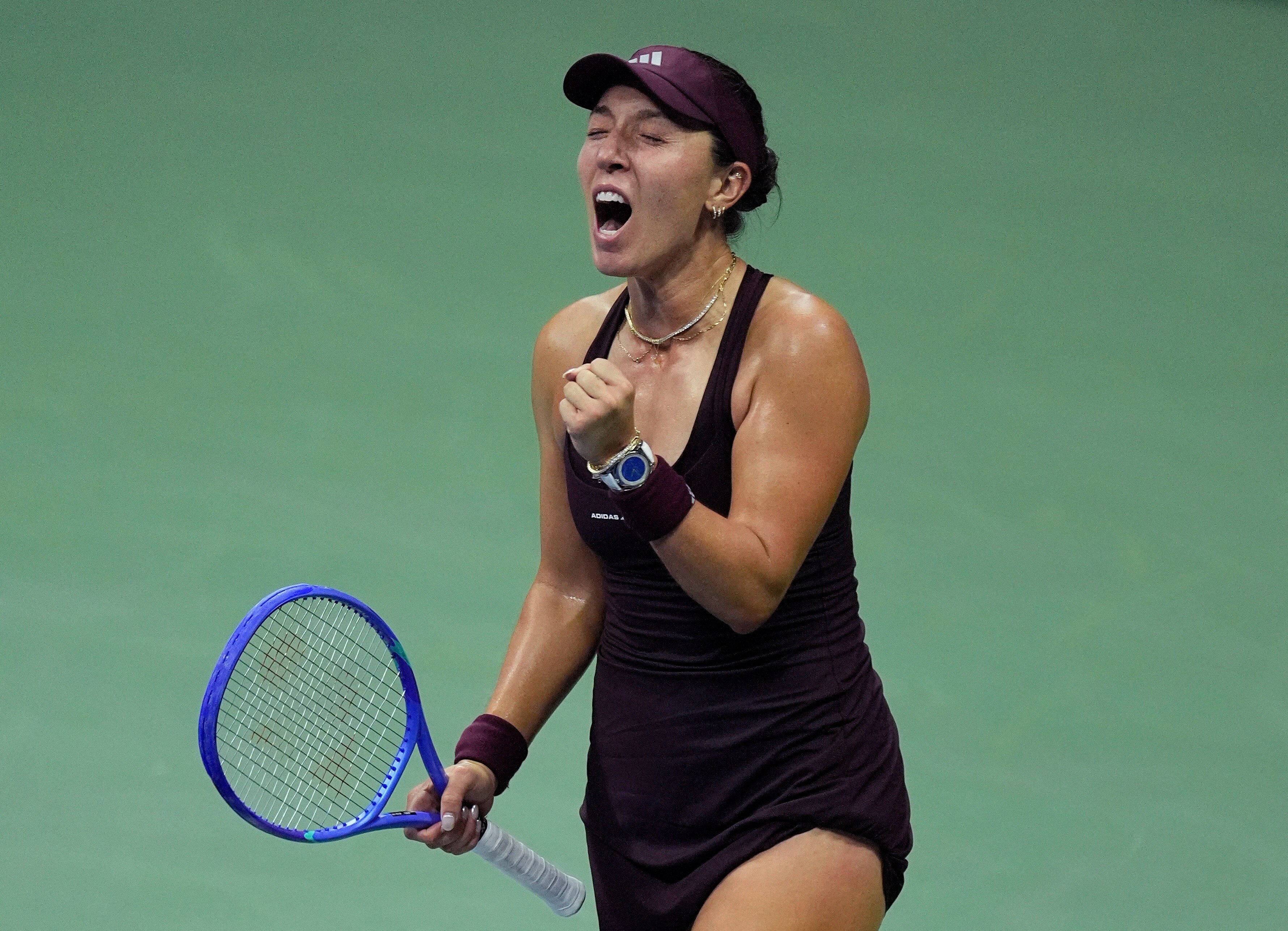 Female tennis player pumps fist, yells with delight, after winning