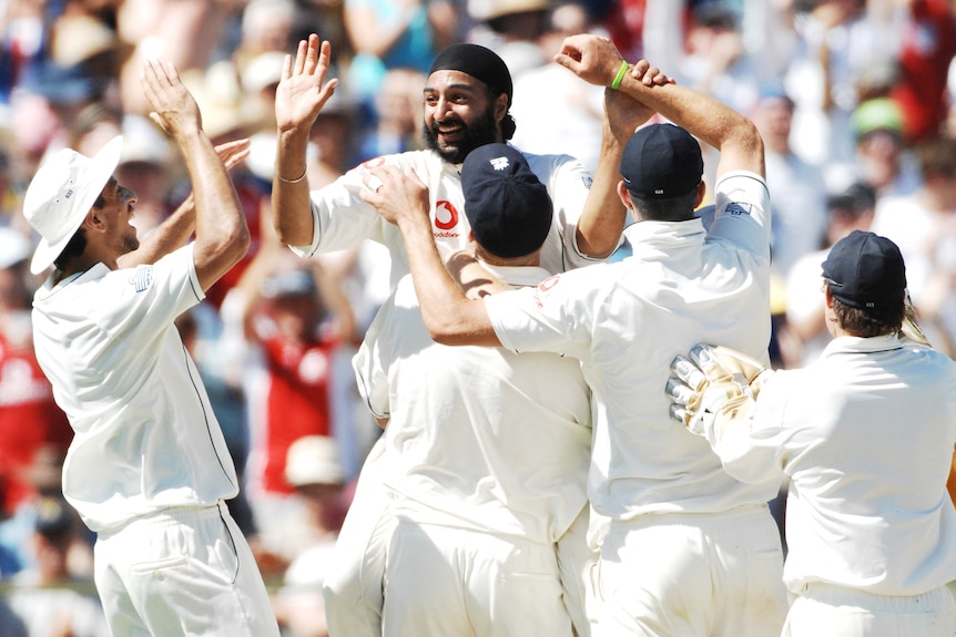 Monty Panesar high-fives teammates after taking the wicket of Australia's Adam Gilchrist at the WACA Ground in December 2006