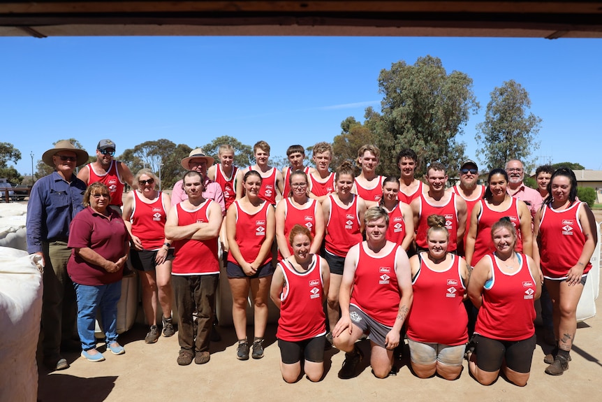 Bruce and Julie Nutt stand to the left next to a group of trainees dressed in red singlets.
