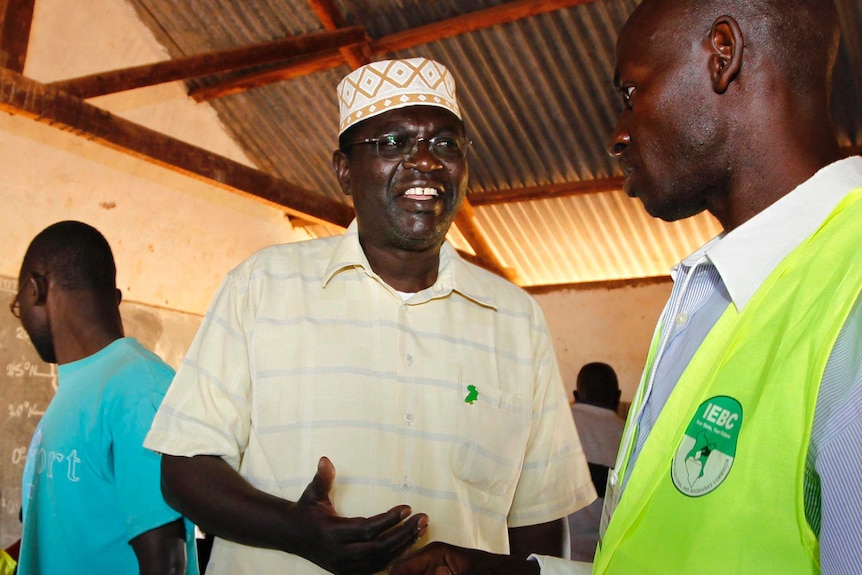 Malik Obama talks to a polling official after voting.