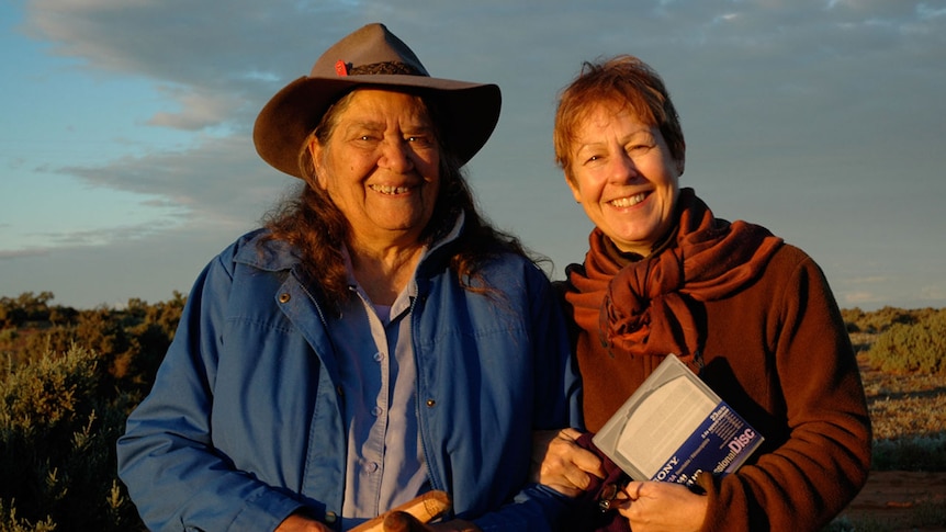 Two women stand outdoors in outback location