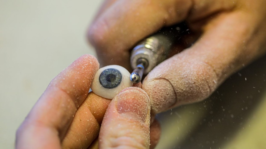 A close-up of tools crafting a prosthetic eye