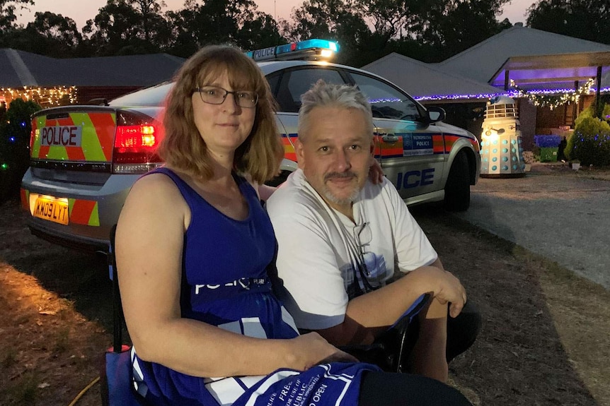 Cassandra and Jayson Whiteley sit in front of their Doctor Who-themed Christmas light display