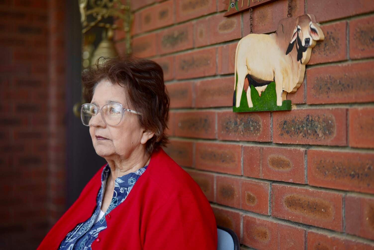 A portrait photo of a woman in a red cardigan