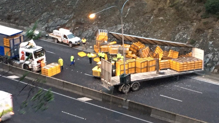 A trailer of a truck with yellow crates spilled over a road