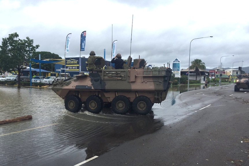 An army tank enters a flooded street in Townsville.