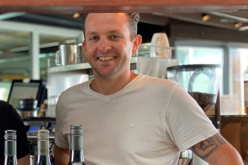 Man smiling at the camera in a restaurant