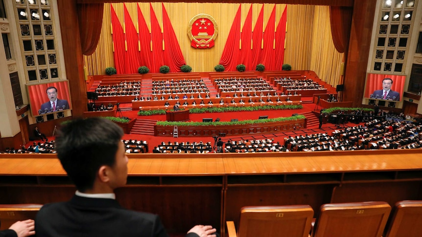 Security officers sit at the back of China's National Peoples Congress