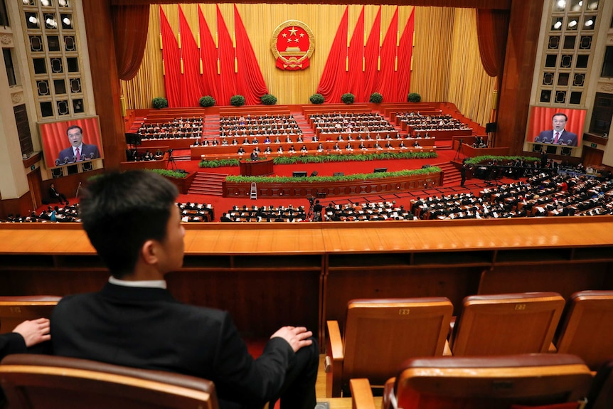 Security officers sit at the back of China's National Peoples Congress