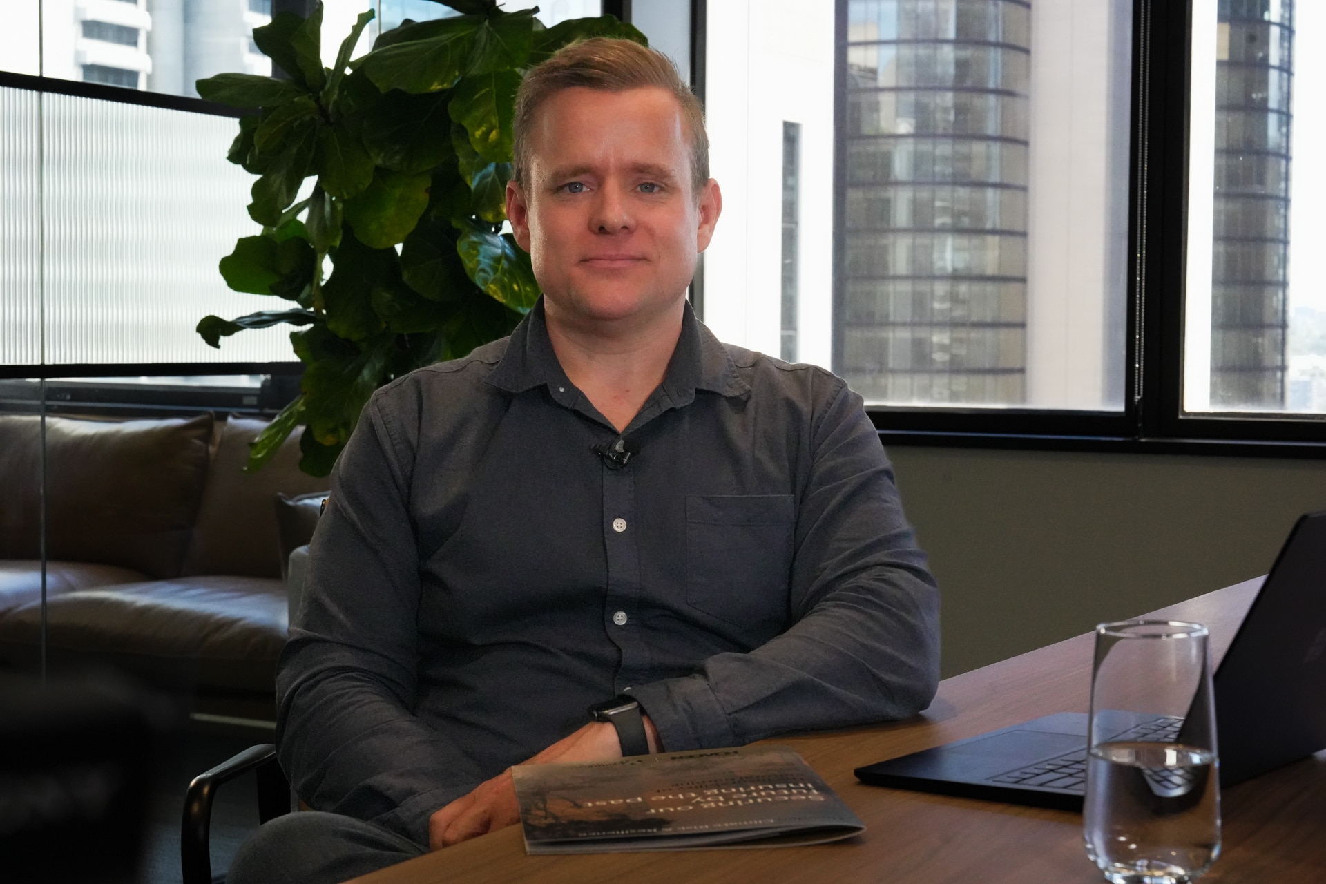 El hombre se sienta en el escritorio y tiene un informe sobre la mesa frente a él