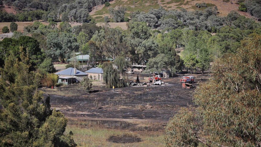 A wide, high view of grass blackened by fire in Wee Jasper.
