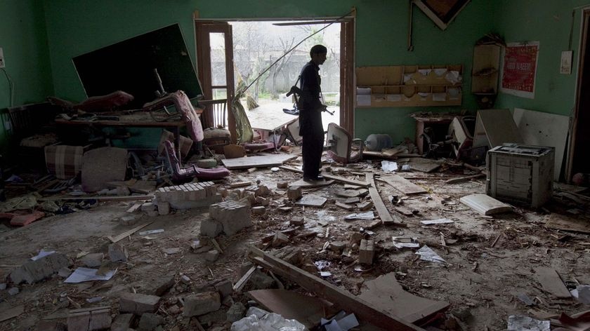 Building attacked: A policeman inspects the destroyed offices of aid group World Vision.
