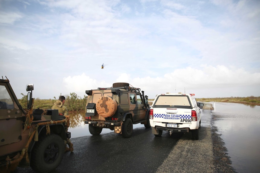 Police and Army vehicles parked at the edge of floodwaters in Boodarie near South Hedland after Cyclone Veronica.
