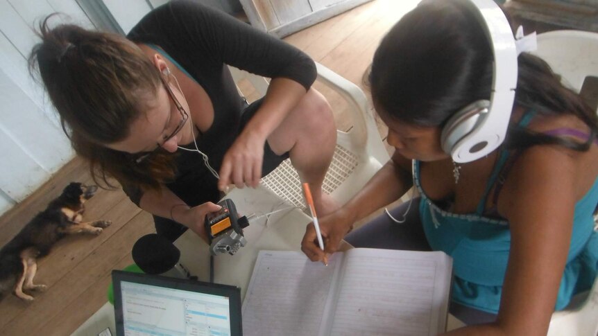 Kasia Wojtylak works with a Murui girl to translate a piece of text.