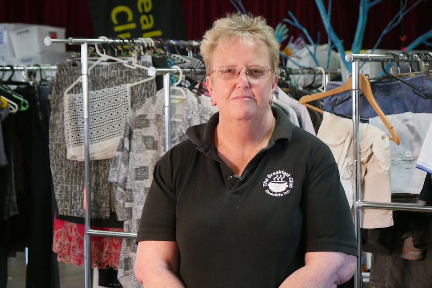 Michelle in front of racks of clothes.