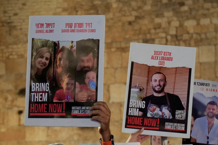 People hold up posters asking for Hamas hostages to be brought home 