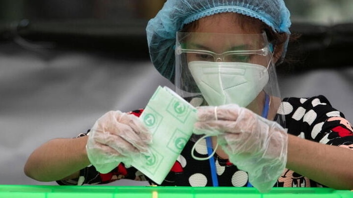 A woman wearing a protective mask casts her ballot during the general election in Yangon, Myanmar.