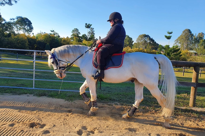 Natalie Smith rides a white horse.