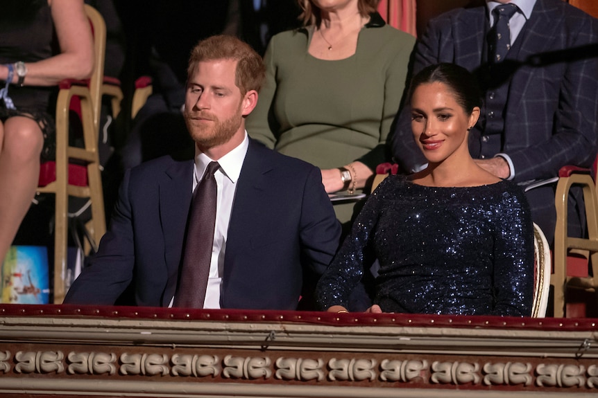 Harry and Meghan sitting in a theatre box
