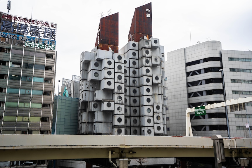 A building that resembles grey Lego blocks stands amid more modern designs